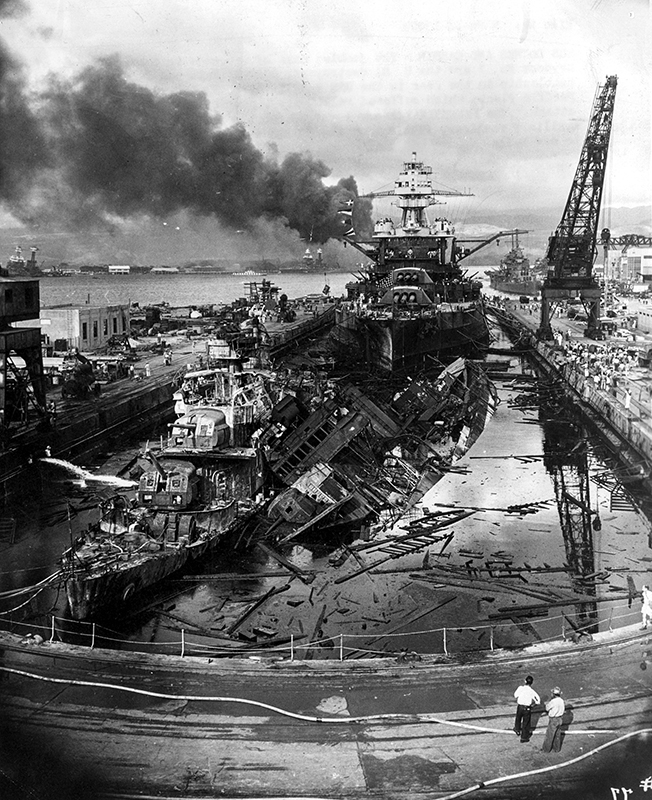 The USS Cassin toppled onto the USS Downes in the flooded drydock at Pearl Harbor, 7 December 1941, with the USS Pennsylvania (BB-38) behind