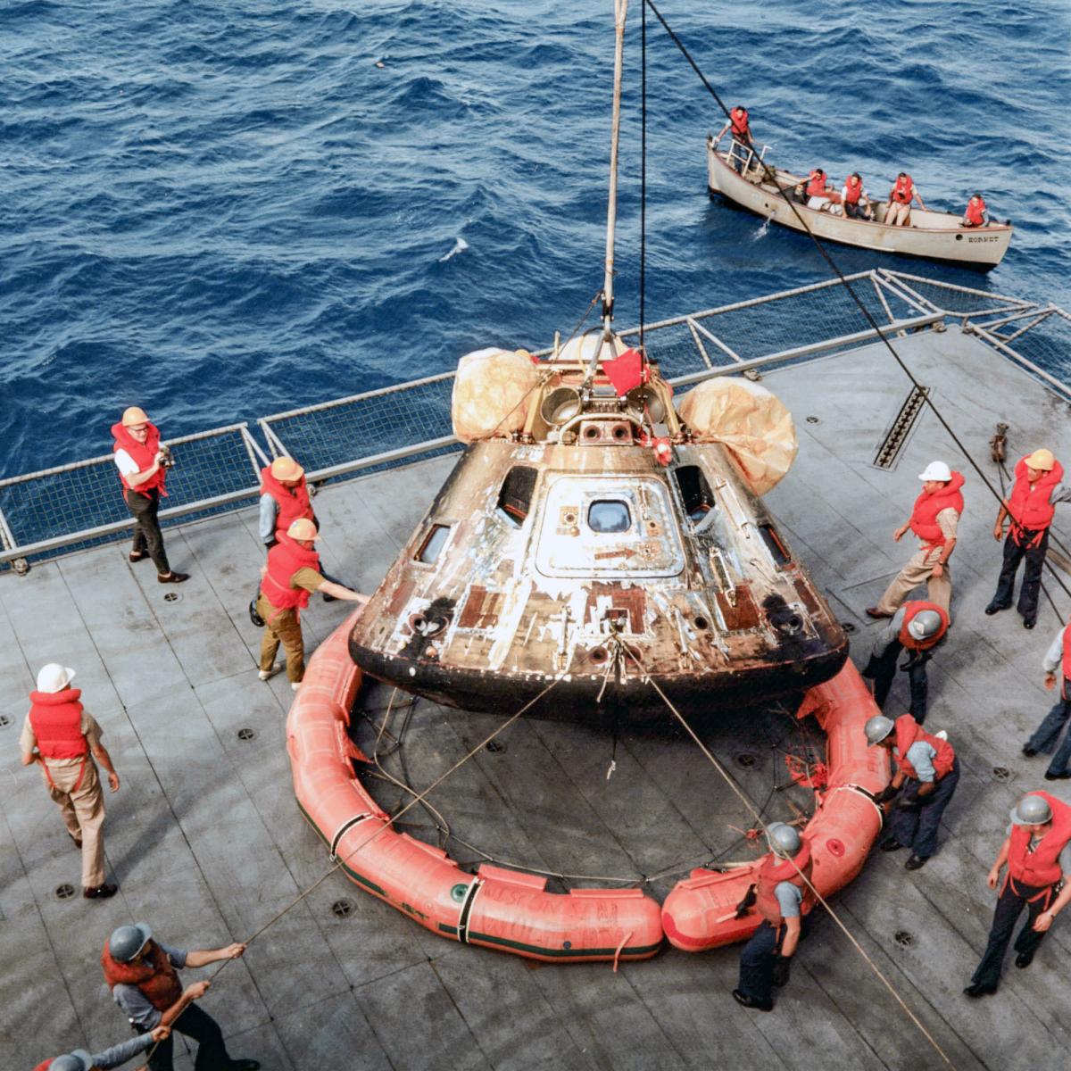 Sailors on board the prime recovery ship, the USS Hornet (CVS-12), remove the flotation ring that had been attached by Navy divers to the Command and Service Module after splashdown.