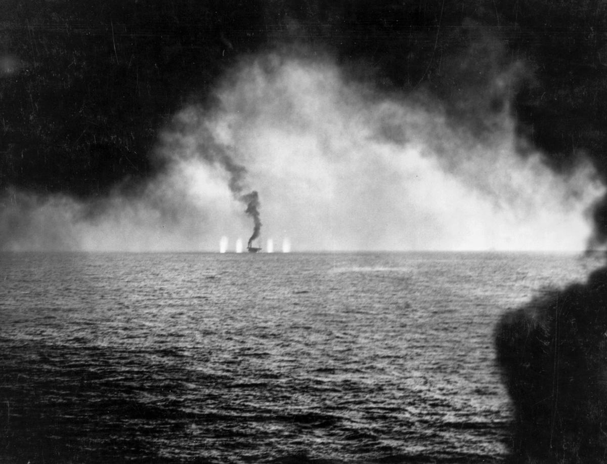 Several near misses straddle the carrier Gambier Bay, but she already is listing from several hits during the Battle of Samar