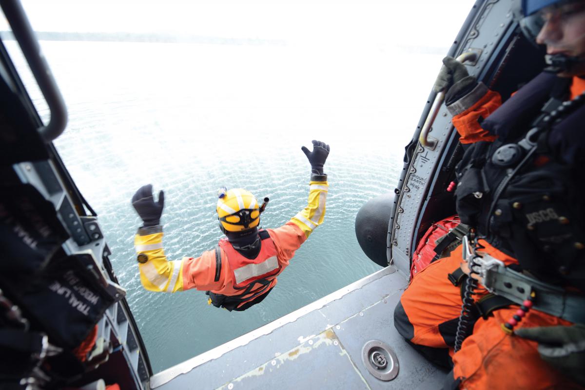 A rescue swimmer  deploys from an MH-60 Jayhawk helicopter into Tillamook Bay, near Garibaldi, Ore., Nov. 21, 2018