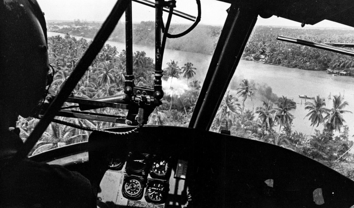 An armed gunship helicopter, flown by a Navy Seawolf, makes a rocket run on a Viet Cong ambush site on the Ham Luong Rive