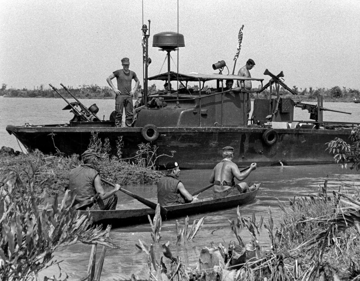 A captured Viet Cong sampan returns to its "mother ship", a U.S. Navy PBR