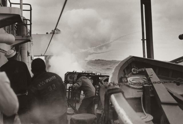 Crewmen on board the Spencer watch a K-gun go into action following detection of the U-boat below the surface.