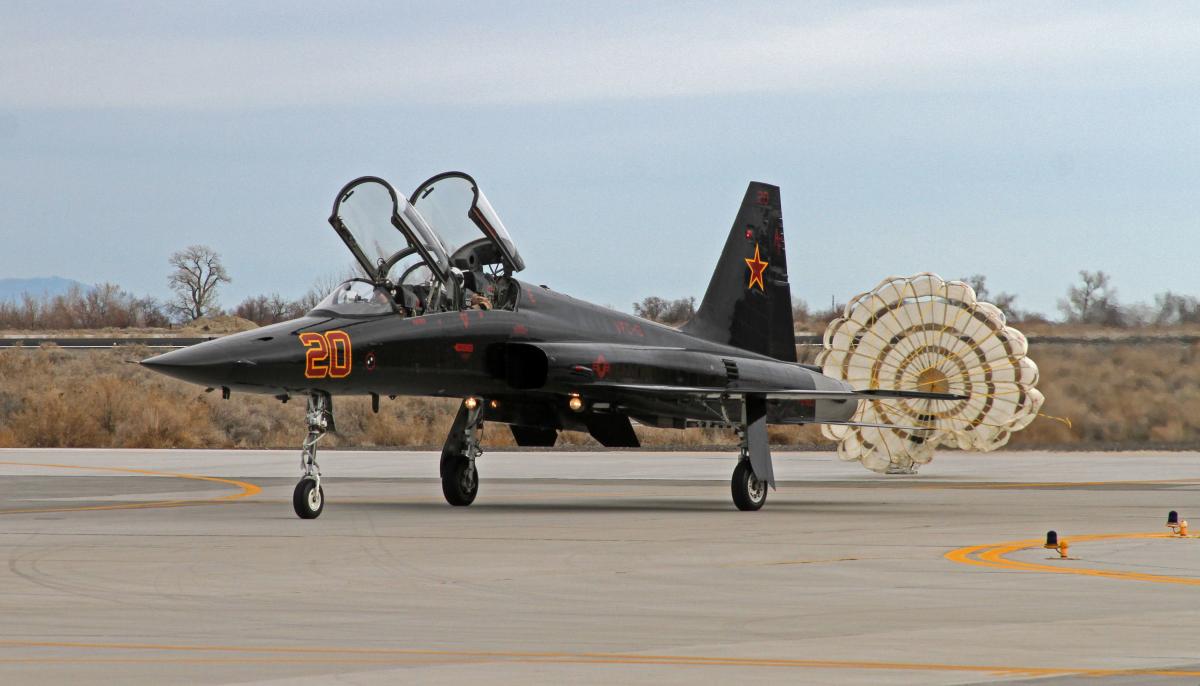  An F-5 Tiger II, attached to the "Saints" of Fighter Squadron Composite (VFC) 13, taxis after deploying a drag parachute upon landing on Naval Air Station Fallon