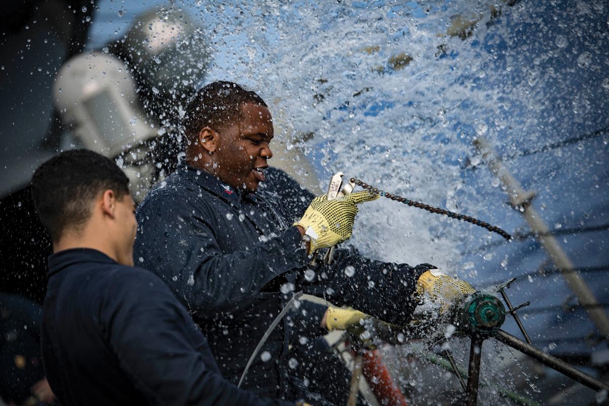 Machinist Mate 2nd Class Dezmond Twymon of the USS Porter (DDG-78) patches a ruptured pipe during the Porter’s damage control olympics in 2018