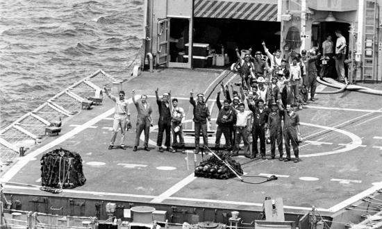 Sailors wave from the deck of the Samuel B. Roberts (FFG-58)