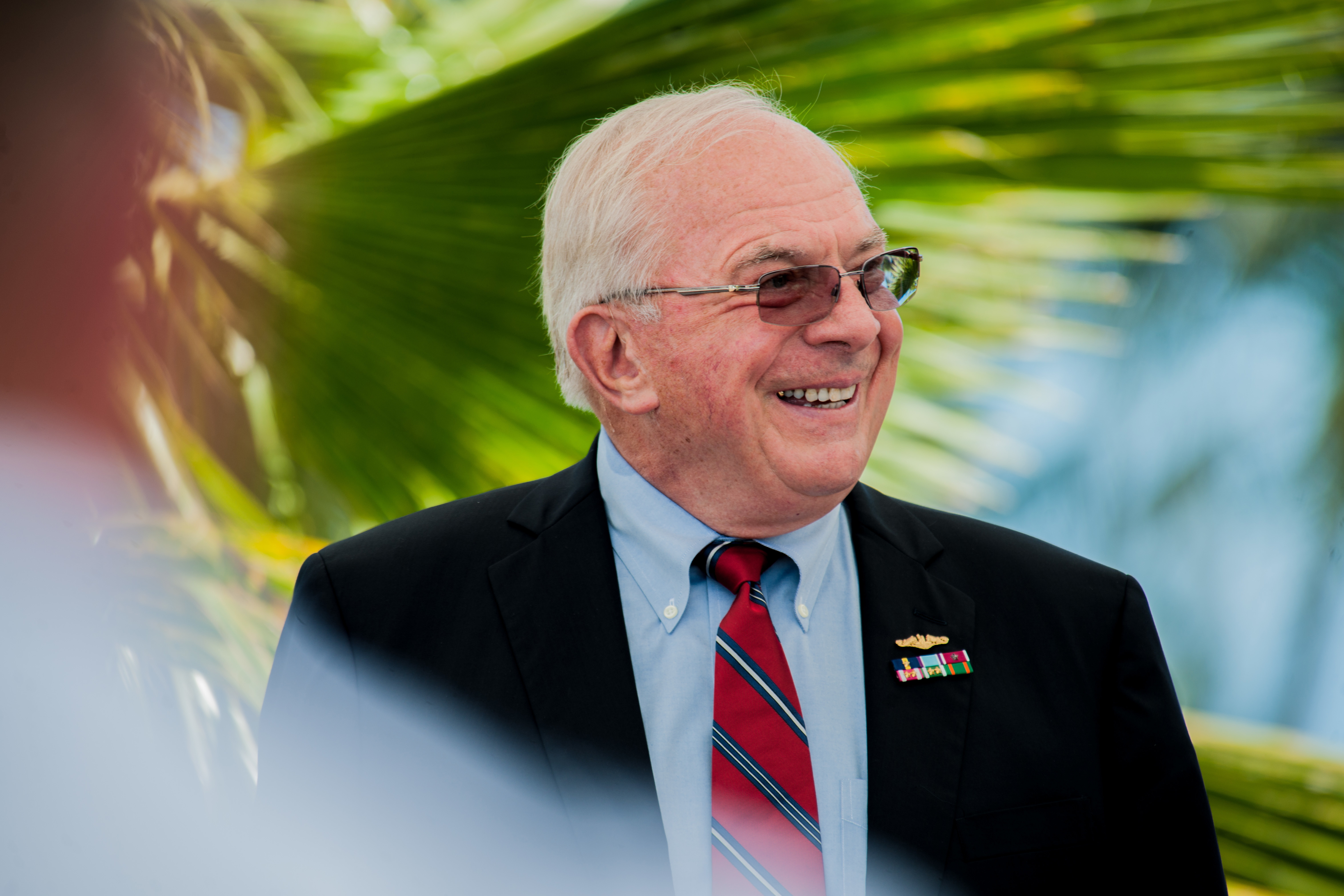Retired Vice Adm. Albert Konetzni laughs at jokes from his former colleagues describing his historic moments as Pacific Fleet Submarine Force commander during the Konetzni Hall building dedication ceremony held at Commander, Submarine Squadron 15 headquarter