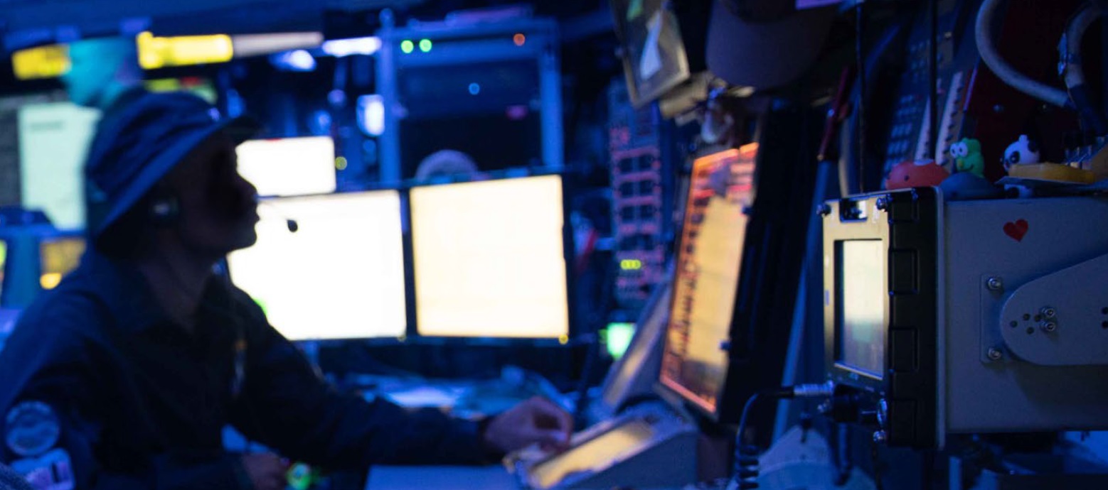 A person sitting in front of several computer monitors.