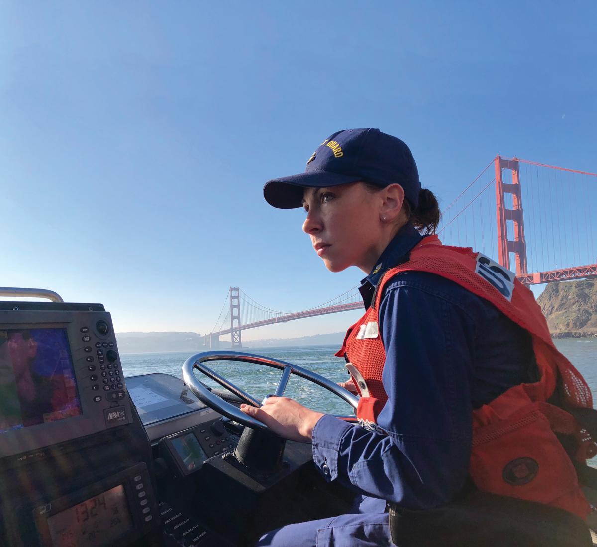Guardsman operating a small boat near the Golden Gate Bridge, San Francisco
