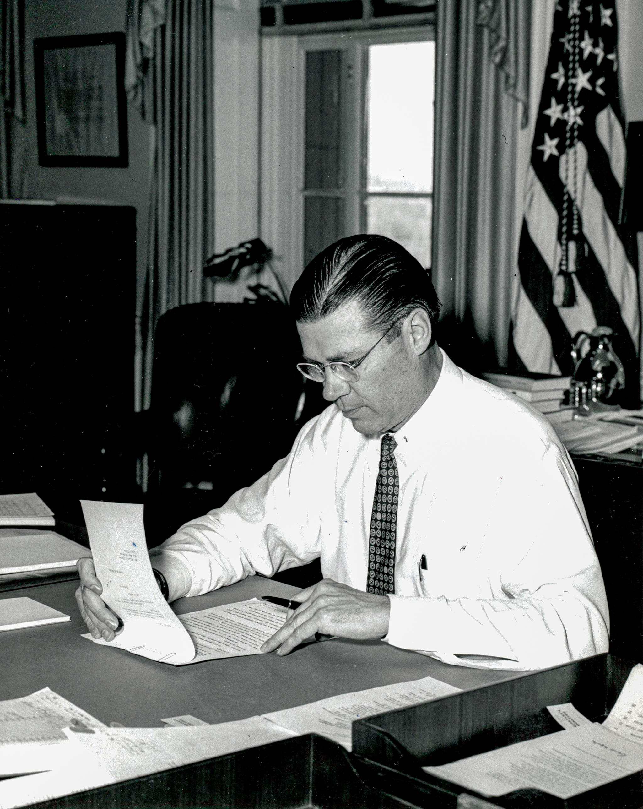 Secretary of Defense Robert McNamara seated in his office at the White House