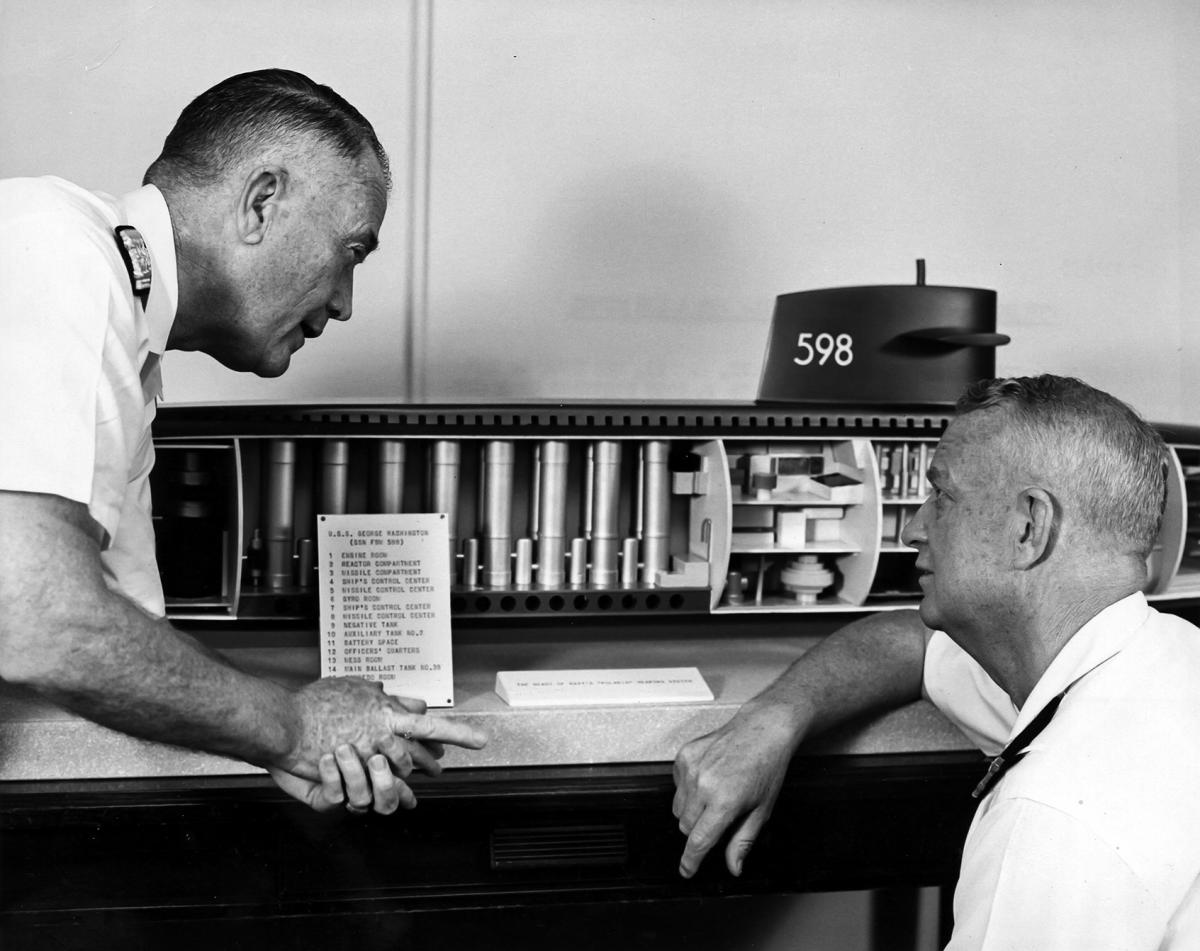 ADM Raborn and ADM Burke looking at a cutaway model of a Polaris missile submarine.