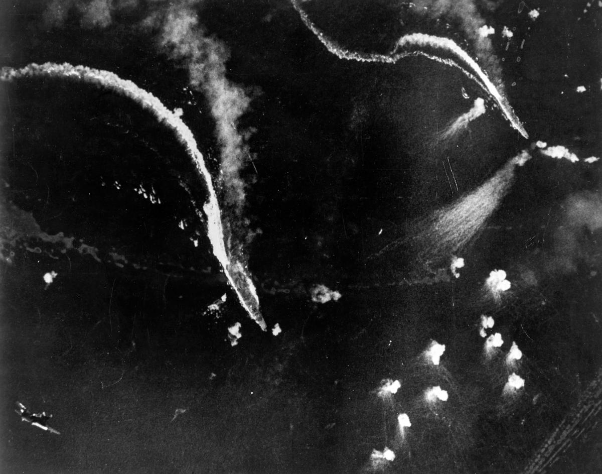 Japanese aircraft carriers Zuikaku (left center) and (probably) Zuiho (right) under attack by U.S. Navy dive bombers during the Battle off Cape Engano. 