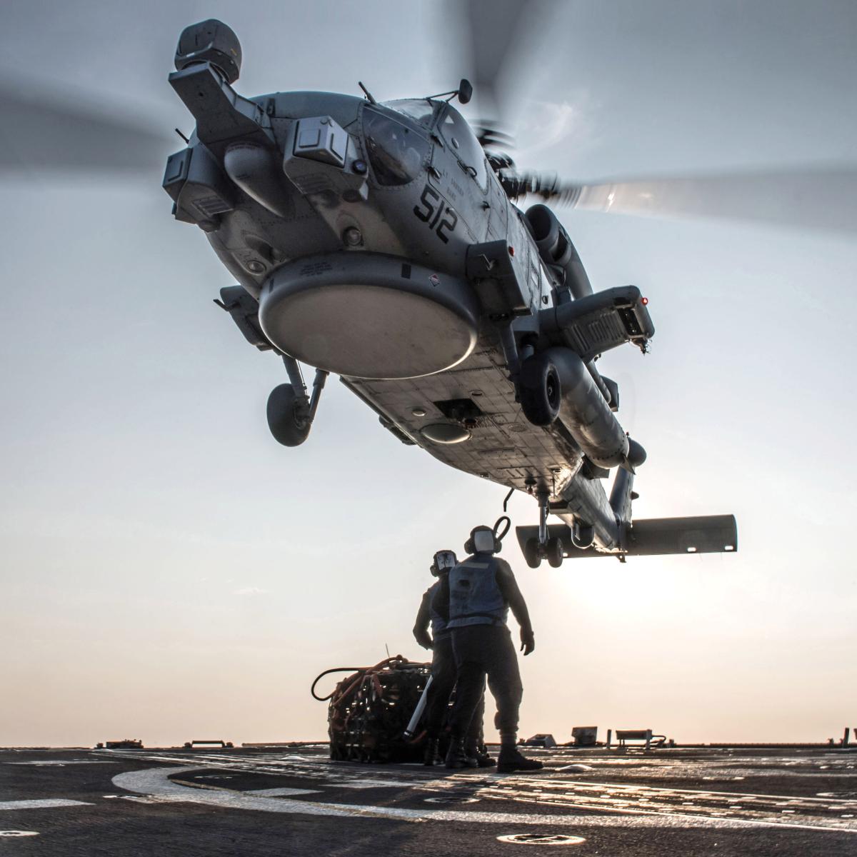 Crewmembers from the USS Jason Dunham (DDG-109) attach pallets to an MH-60R Seahawk helicopter from Helicopter Maritime Strike Squadron 48 (“The Vipers”), in November 2018
