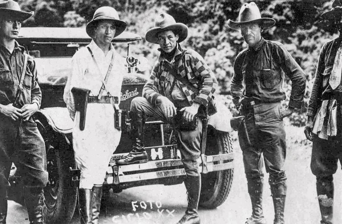 Augusto Sandino posing with others by an automobile