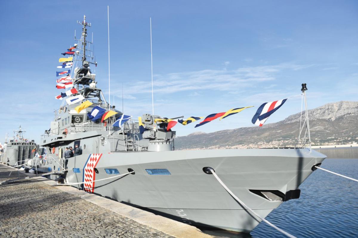 Starboard bow view of the Croatian patrol vessel Omiš moored to a seawall, dressed overall for her commissioning