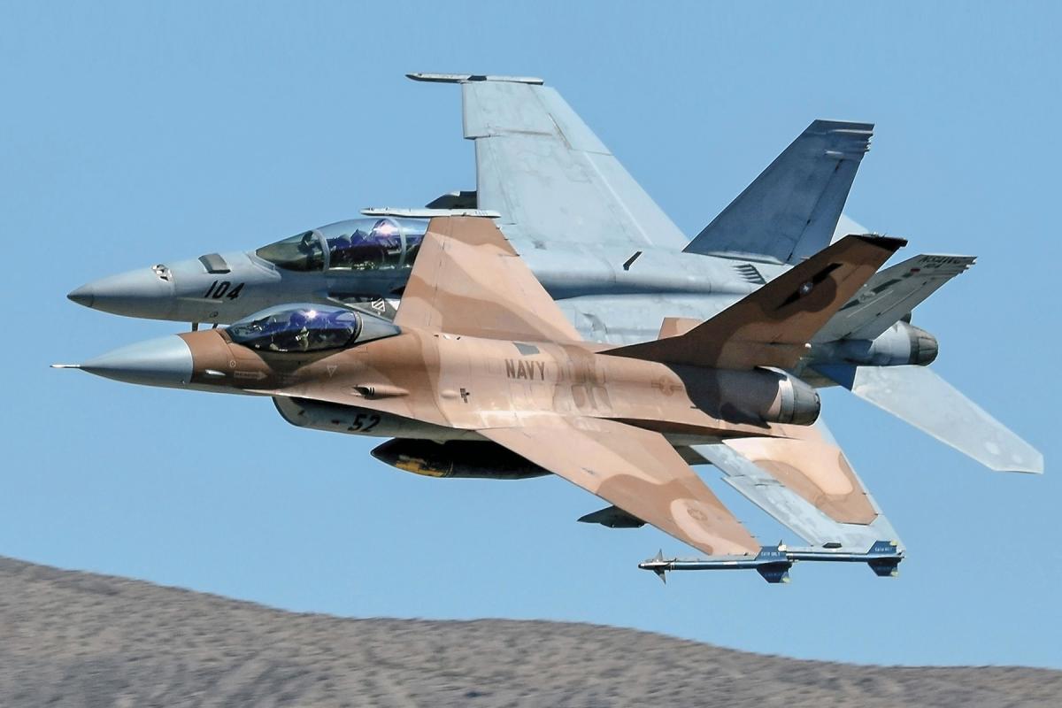An F-16N and a F-18 Hornet flying in formation