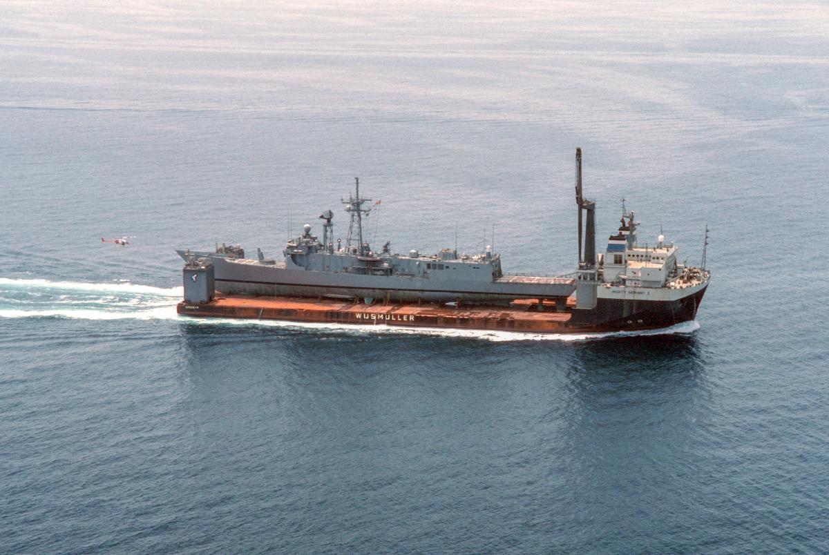 An aerial starboard view of the Dutch heavy-lift ship MIGHTY SERVANT 2 underway with its cargo, the guided missile frigate USS SAMUEL B. ROBERTS (FFG 58), secured on deck