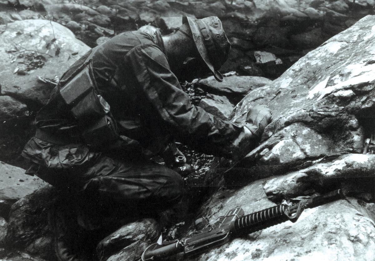 Marine pausing to fill his canteen during a 1st Reconnaissance Battalion patrol in the mountains west of Da Nang
