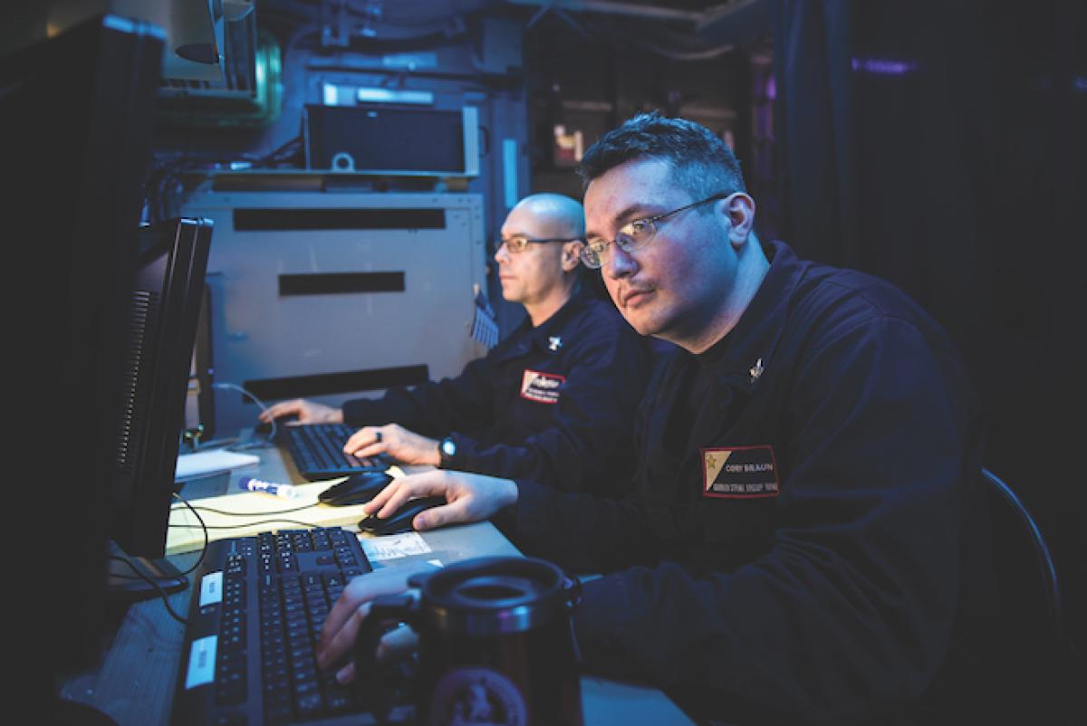Sailors monitoring tactical data links in the Tactical Flag Control Center aboard the aircraft carrier USS Theodore Roosevelt (CVN-71)