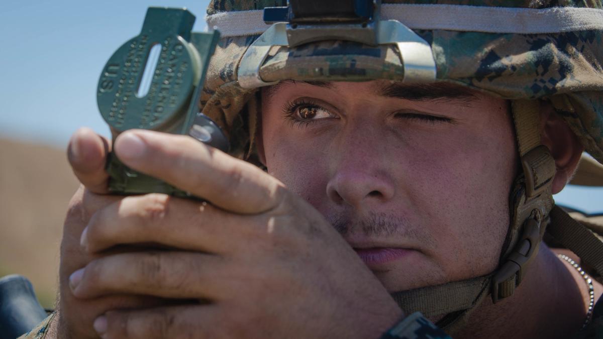 A U.S. Marine looks through a lensatic compass