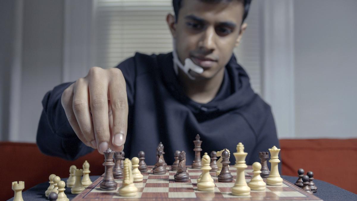 Chess player wearing MIT’s AlterEgo playing a game of chess