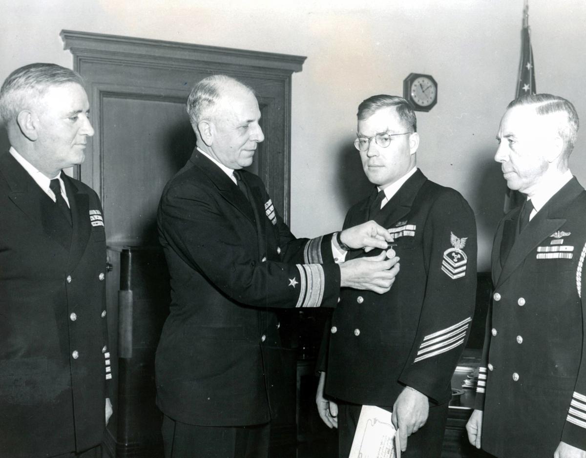 Chief Machinist Mate Richard McKenna is shown here in 1949 receiving the Naval Institute’s Gold Medal from Rear Admiral J. Cary Jones, U.S. Navy, Commandant of the Ninth Naval District