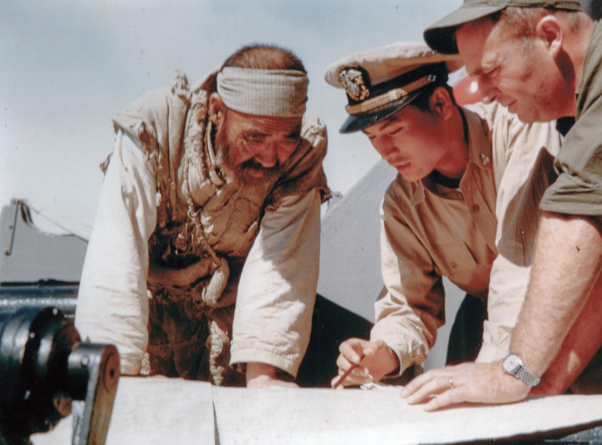 A South Korean Navy officer and a U.S. Navy underwater demolitions officer query a fisherman