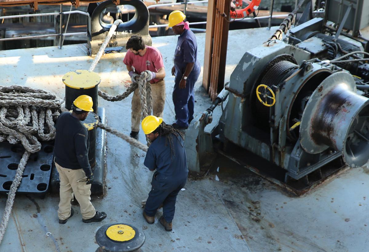 Civilian mariners attached to USNS PFC Eugene A. Obregon (T-AK-3006) prepare to get under way.