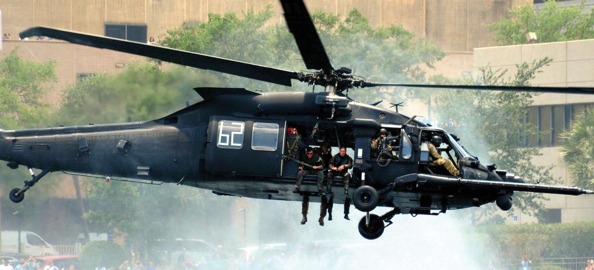 Right side ground-to-air view of a U.S. Army Blackhawk helicopter with solidiers embarked in flight