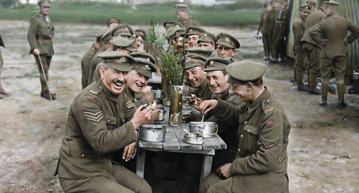 British soldiers laughing while eating at a table