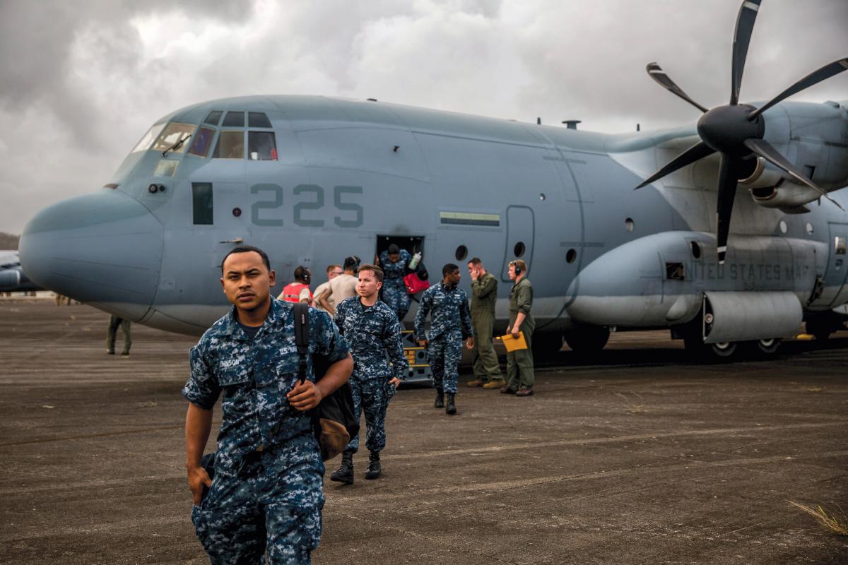 U.S. Marines and Sailors exit a KC-130J Super Hercules aircraft.
