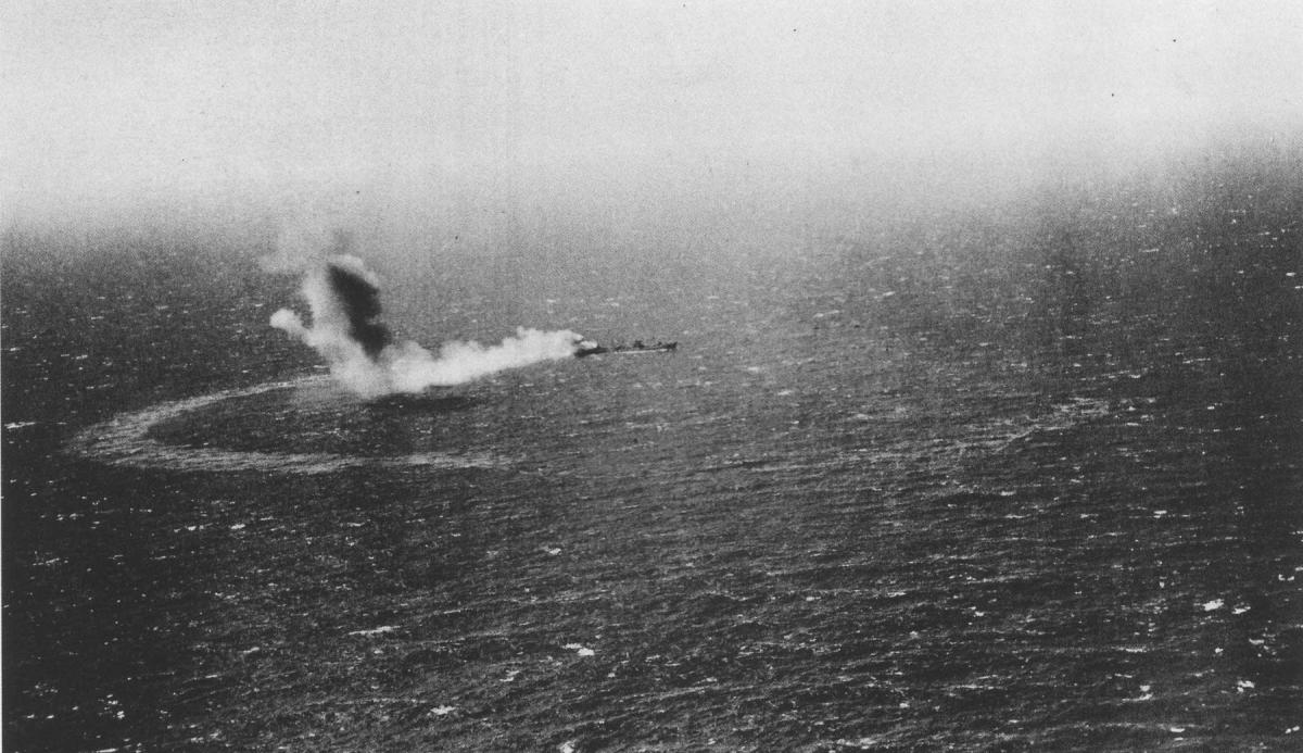 Smoke pours from the stern of the Neosho as she trails a ribbon of oil in a photo taken from an attacking Japanese D3A dive bomber on 7 May 1942.