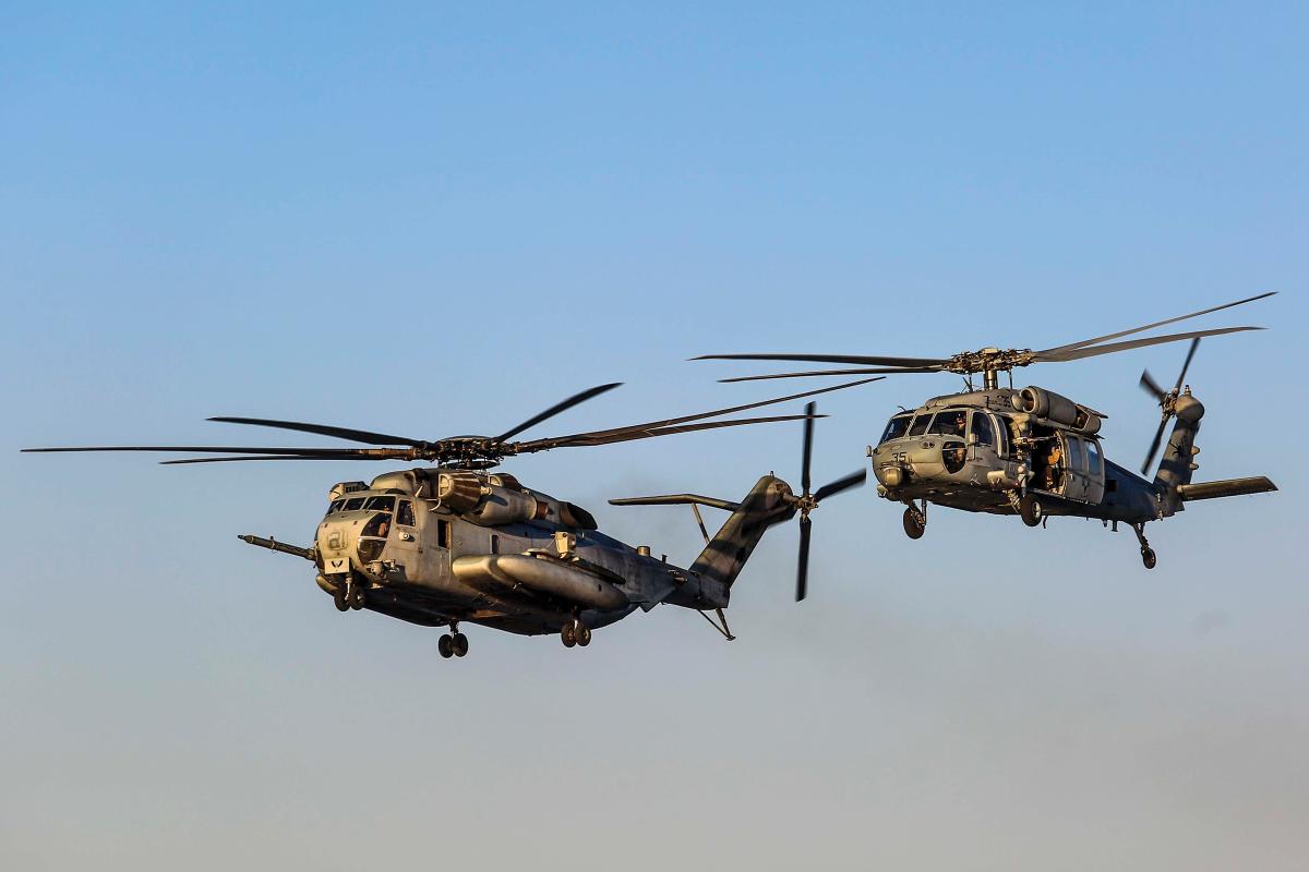 A U.S. Marine Corps CH-53E Super Stallion with Marine Medium Tiltrotor Squadron (VMM) 162, 26th Marine Expeditionary Unit and a U.S. Navy MH-60S Seahawk with Helicopter Sea Combat Squadron (HSC) 28 , conduct a flyby of the Wasp-class amphibious assault ship USS Iwo Jima (LHD07), May 13, 2018