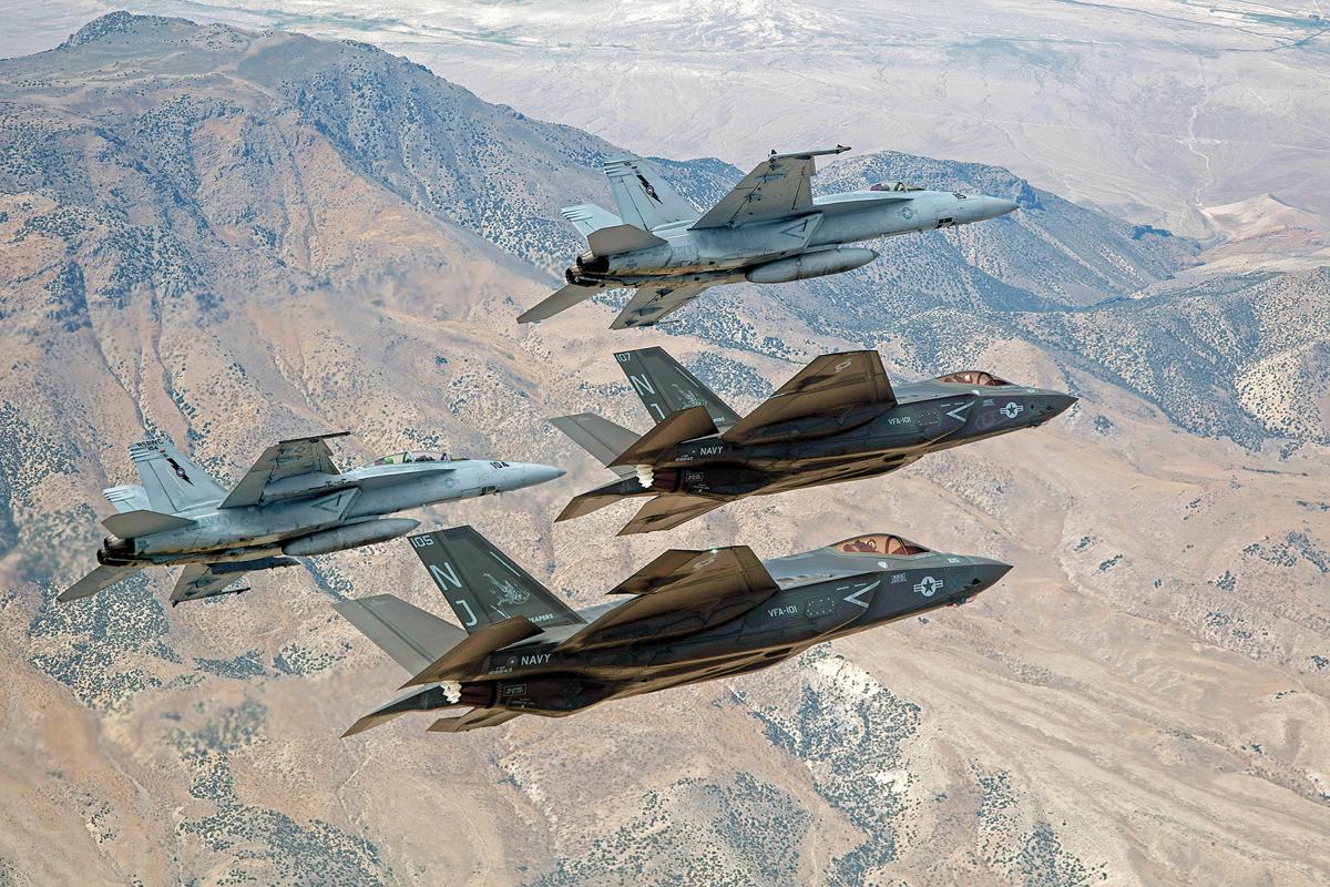 F-35C Lightning IIs, attached to the Grim Reapers of Strike Fighter Squadron (VFA) 101, and an F/A-18E/F Super Hornets attached to the Naval Aviation Warfighter Development Center (NAWDC) fly over Naval Air Station Fallon's (NASF) Range Training Complex