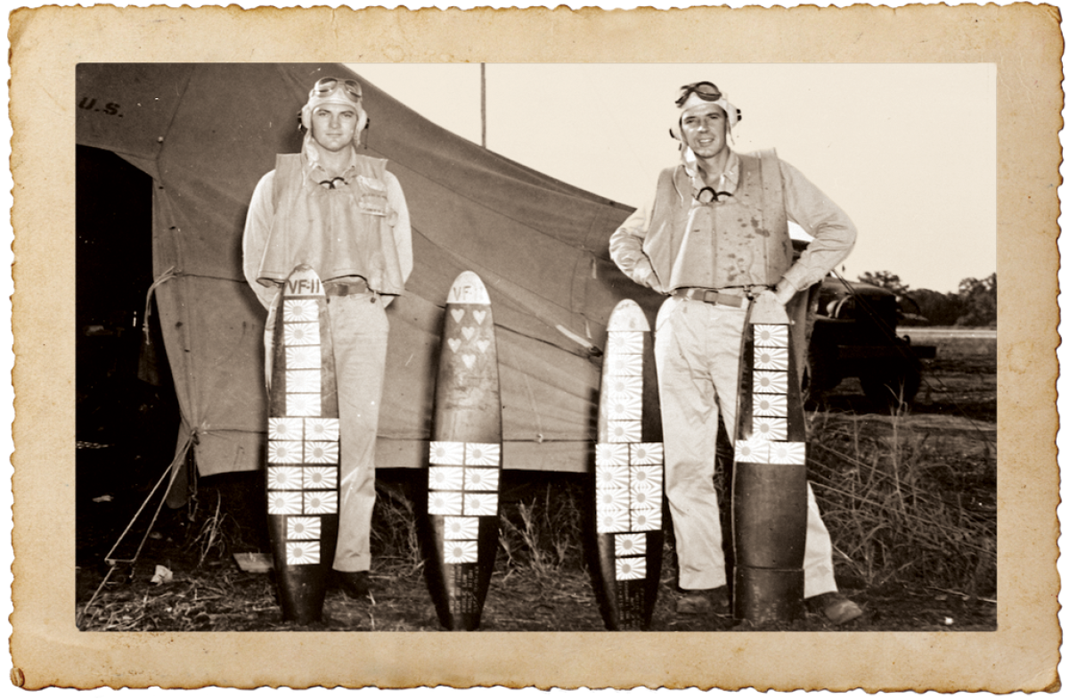 Lieutenant Commander Charles White standing with Lieutenant Raymond Vogel with squadron scoreboards
