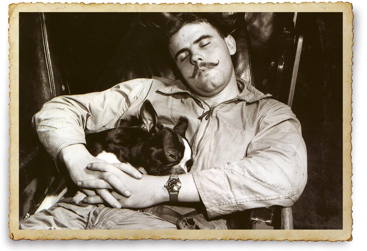 Lieutenant (junior grade) Blake Moranville sleeping with the squadron dog mascot Gunner
