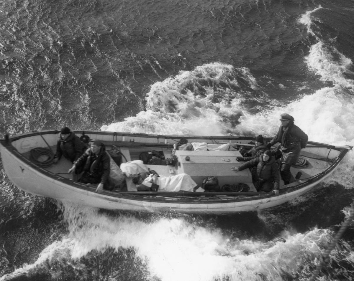 A surfboat from the cutter Yakutat carries two survivors from the tanker Mercer's bow section