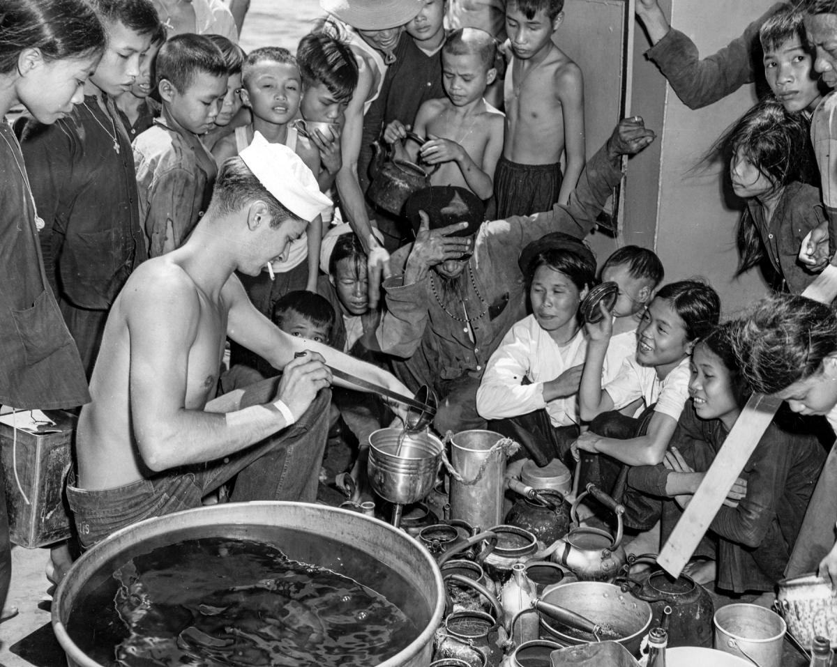 On board ship, the Navy’s Vietnamese passengers line up for tea.