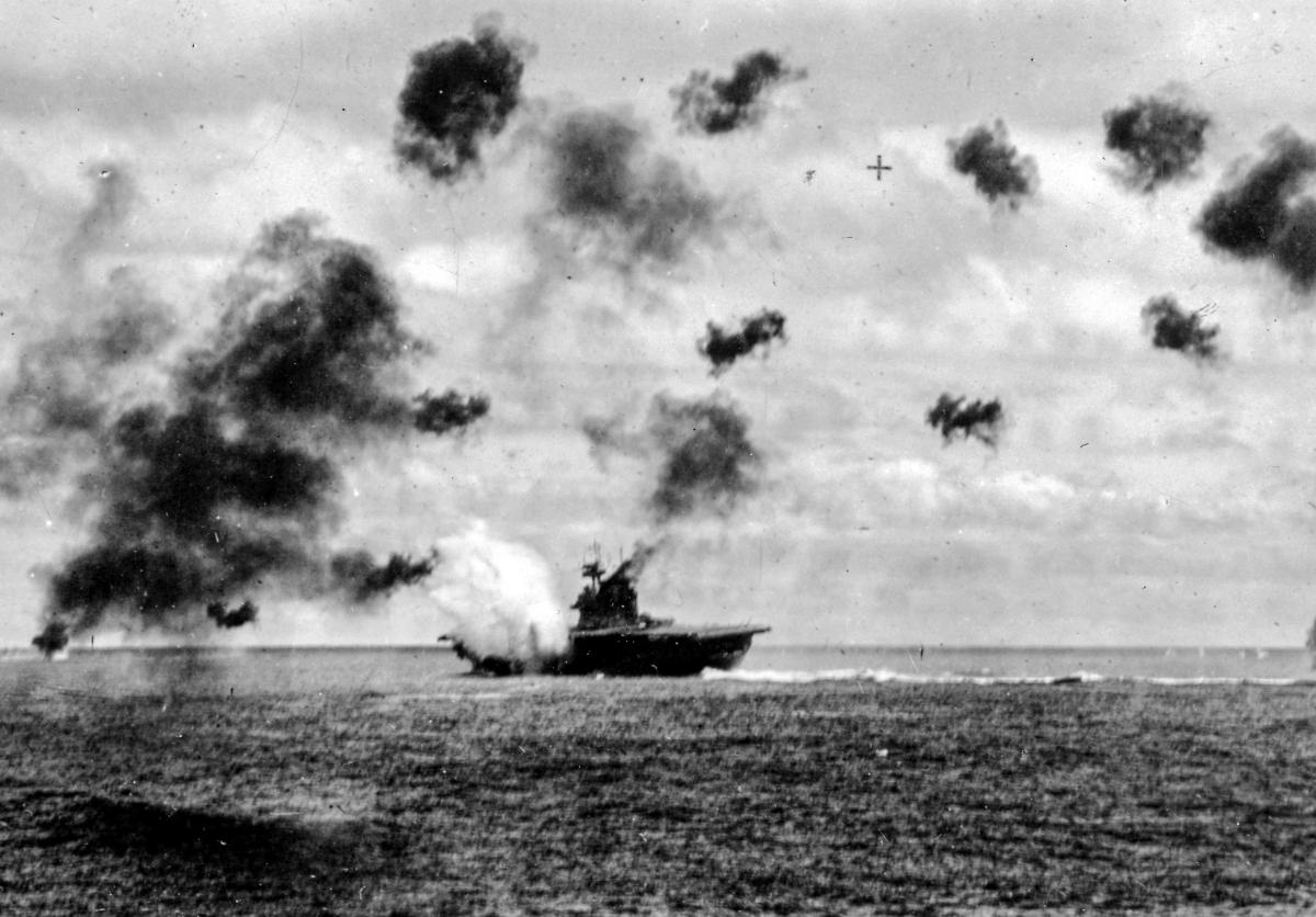 The USS Yorktown (CV-5) is hit by one of two torpedoes that slammed into her port side during the aerial strike