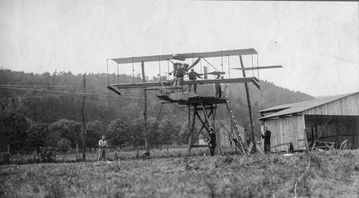 Ellyson sitting in a hydroaeroplane atop a wire-launching device
