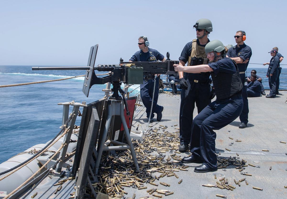 A sailor practices firing a machine gun.