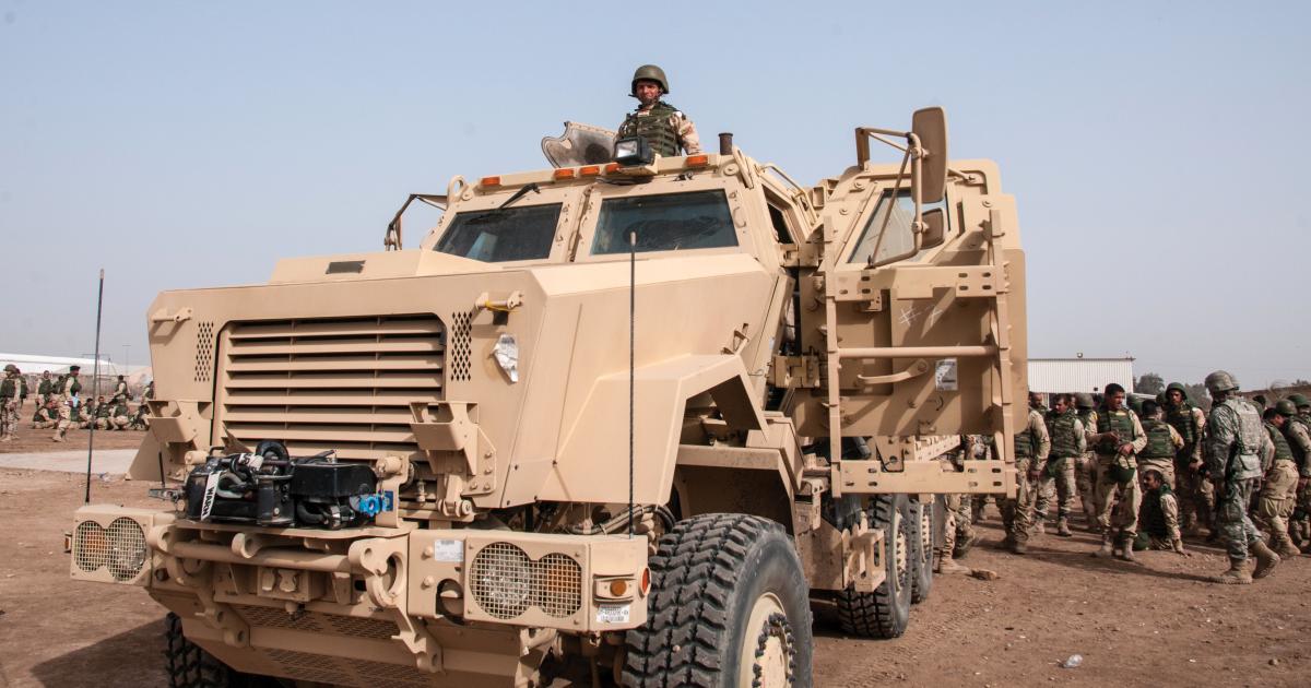 An Iraqi army trainee peers from the turret of a mine-resistant ambush-protected vehicle (MRAP)