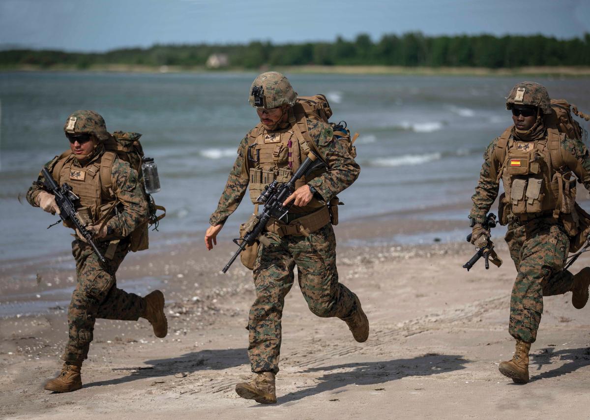 U.S. Infantry Marines sprint after landing on a beach during an amphibious assault exercise