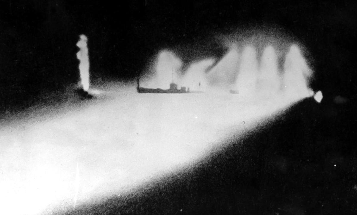 An American ship illuminated by searchlights being shelled by the Chokai's 20-cm. guns.