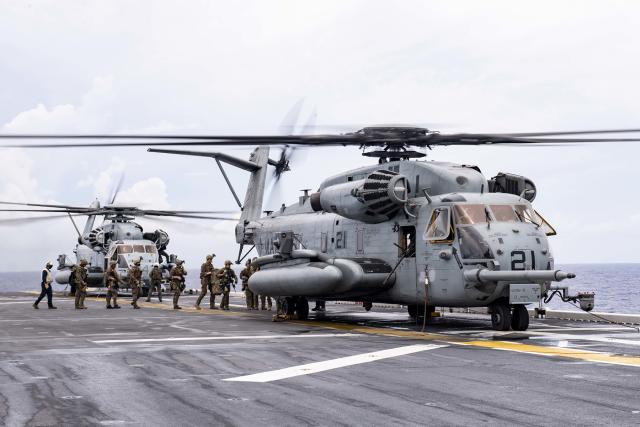 Marines board a CH-53 Super Stallion on the flight deck of the USS America (LHA-6) to conduct a visit, board, search, and seizure exercise. U.S. Navy (Vincent E. Zline)