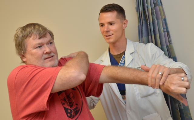 Navy doctor of osteopathic medicine assesses a veteran’s shoulder