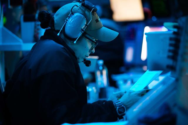 The operations officer for the USS Carney (DDG-64) stands tactical action officer watch in the ship’s combat direction center on 9 October.