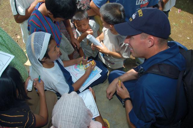 A sailor from the hospital ship USNS Mercy (T-AH-19) talks with Filipino children during Pacific Partnership humanitarian and community outreach activities on the island of Mindanao. Basing a hospital ship in the western Pacific would allow the United States to more rapidly support allies partners with humanitarian assistance when needed.