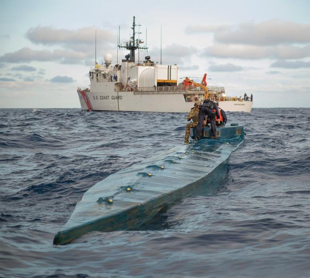 U.S. Coast Guard members offload contraband from a low-profile go-fast vessel to the U.S. Coast Guard Cutter Mohawk (WMEC-913) in the eastern Pacific.