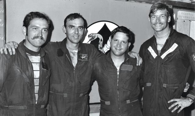 Smiling naval aviators Lieutenant (junior grade) Jay Tinker, Lieutenant Austin Hawkins, Lieutenant Commander Jim McDevitt, and Dosé stand  together after the latter two’s 10 May 1972 MiG-21 shootdown. Tinker and McDevitt were the backseaters—radio intercept officers—in Hawkins’ and  Dosé’s respective planes.